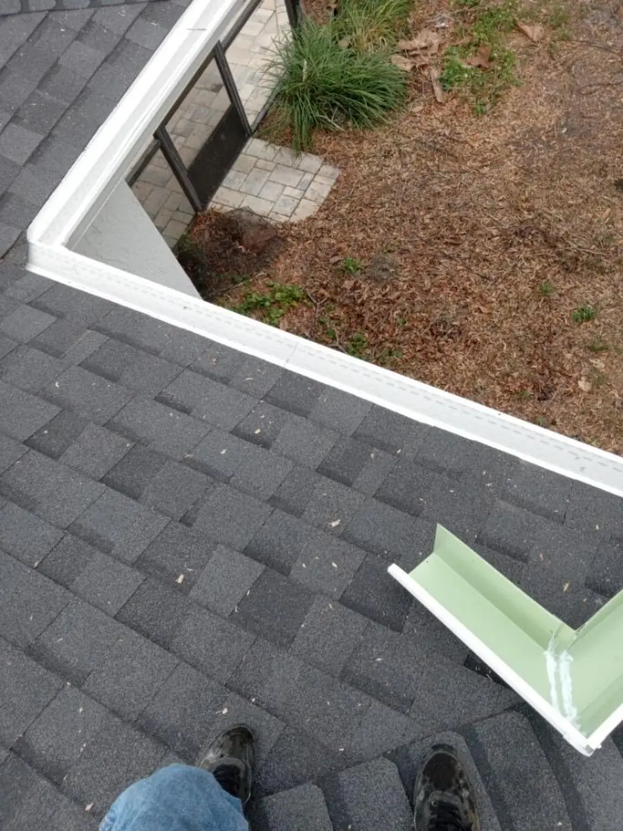 K-style gutter guard section being fitted to a gutter run