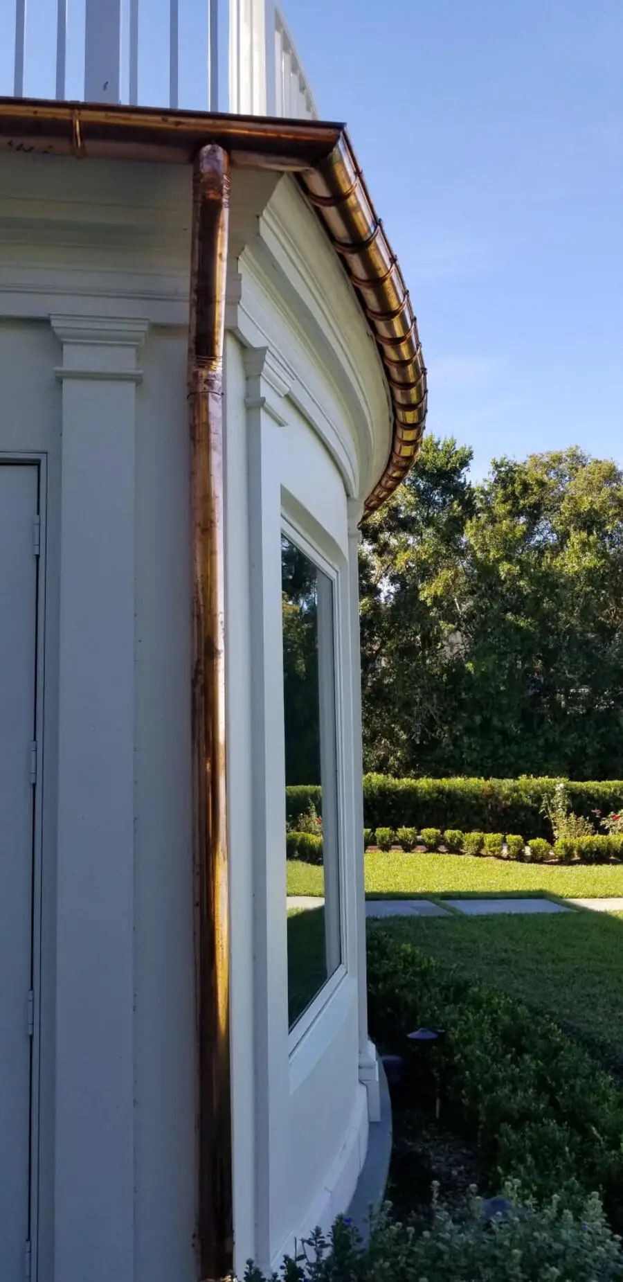 Copper half-round gutter installed on a curved turret roofline