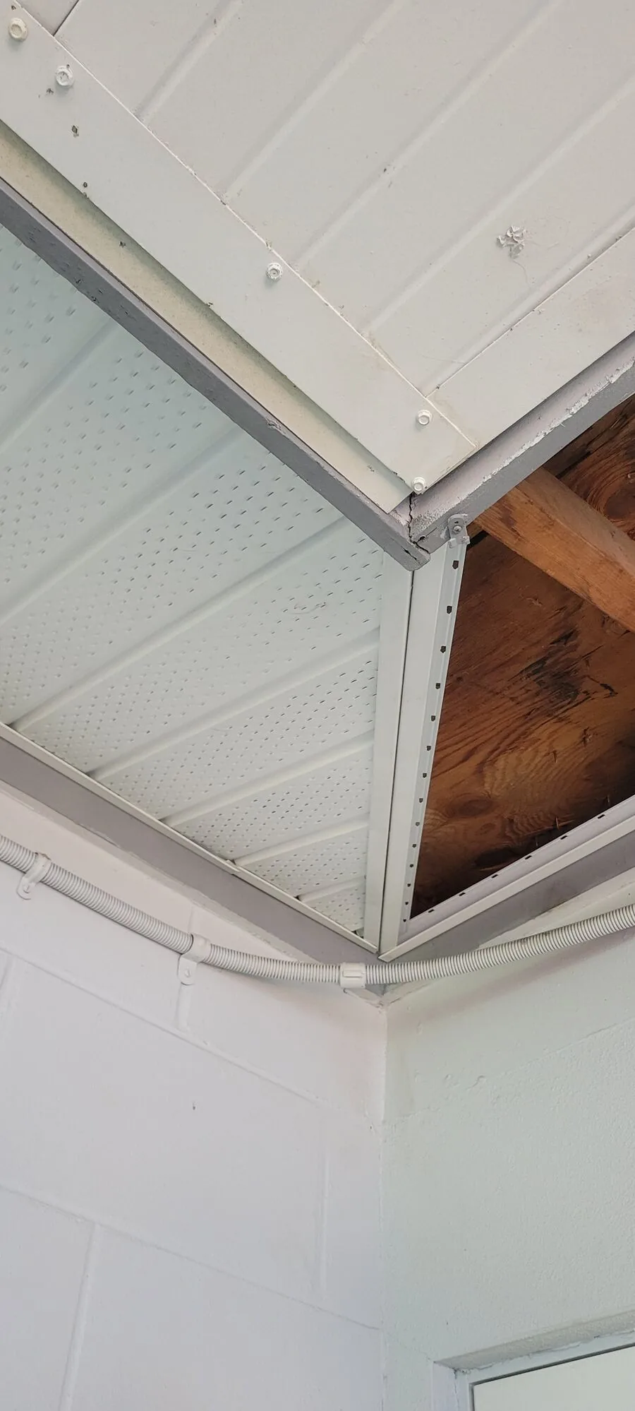 Soffit replacement in progress with old panels removed and framing exposed
